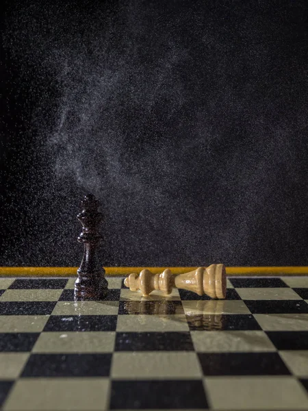 Figuras de ajedrez sobre un fondo oscuro bajo la lluvia . — Foto de Stock