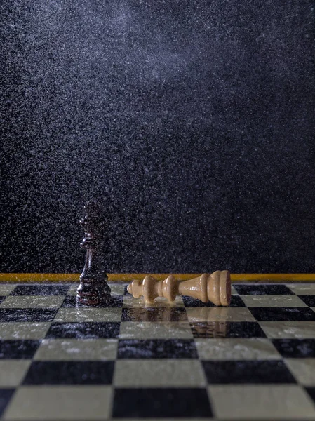 Figuras de ajedrez sobre un fondo oscuro bajo la lluvia. Perder y ganar Concepto . — Foto de Stock