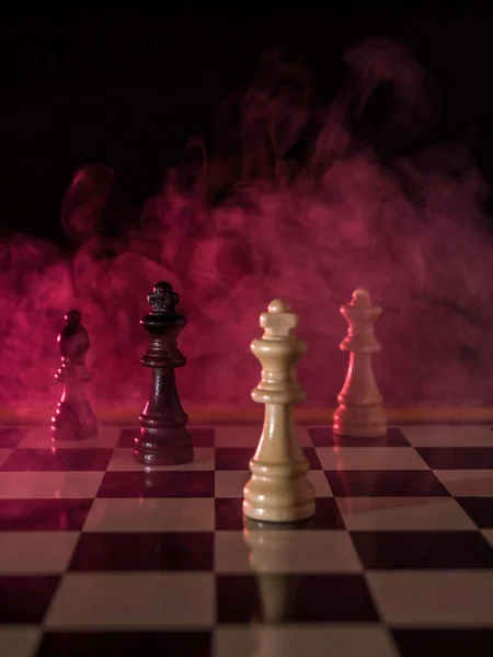 Figuras de ajedrez sobre fondo oscuro con humo rojo y niebla . — Foto de Stock