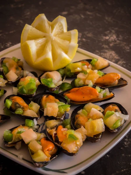 Siyah taş tabakta servis edilen vinaigrette midyeleri.