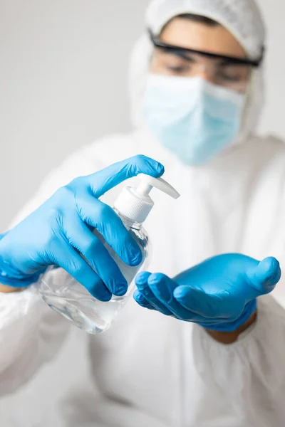 Coronavirus covid-19 'a karşı lateks eldivenli ve koruyucu giysili araştırmacı ellerini alkolle yıkayarak