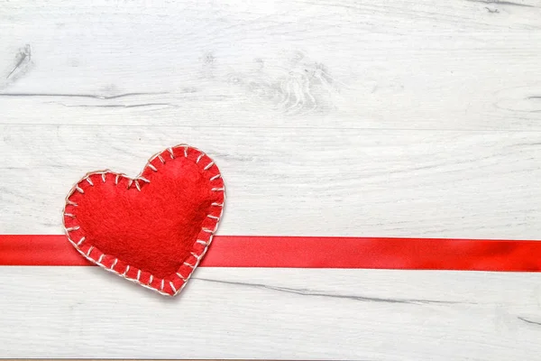 Red hearts and red ribbon on a white wooden background. Flat lay, top view, copy space.