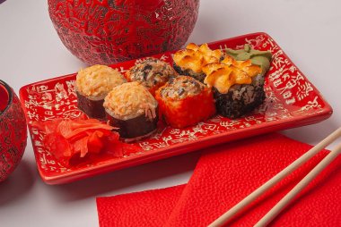 Kırmızı tabakta suşi. Tabakta dilimlenmiş suşi..