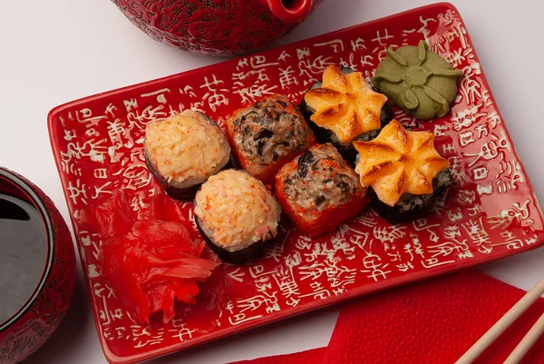 Kırmızı tabakta suşi. Tabakta dilimlenmiş suşi..