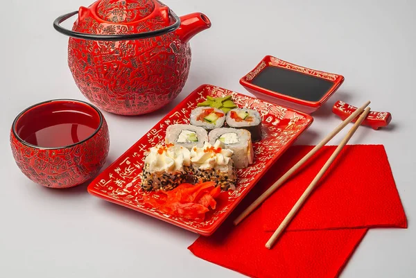 Beyaz arka planda kırmızı tabaklarda suşi.