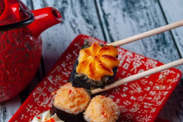 Kırmızı tabakta suşi. Tabakta dilimlenmiş suşi..