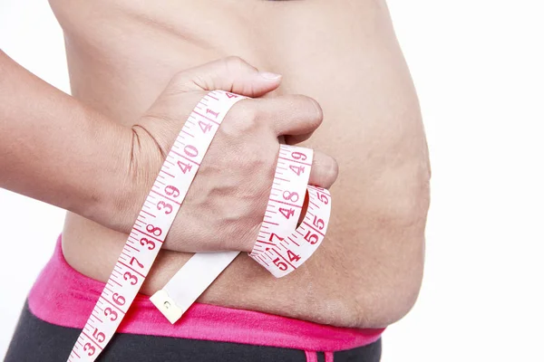 Fet kvinna klämmande hennes feta mage på vit bakgrund. — Stockfoto