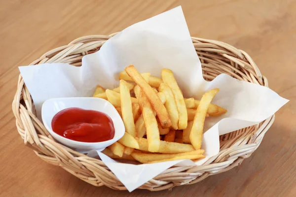 Pommes mit Ketchup auf Holzgrund — Stockfoto