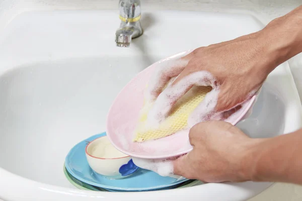 Man washing dish in sink.Concept for Health