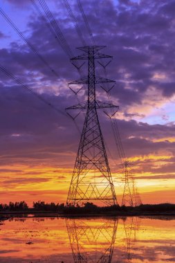 Siluet yüksek gerilim elektrik hatları gün batımında.