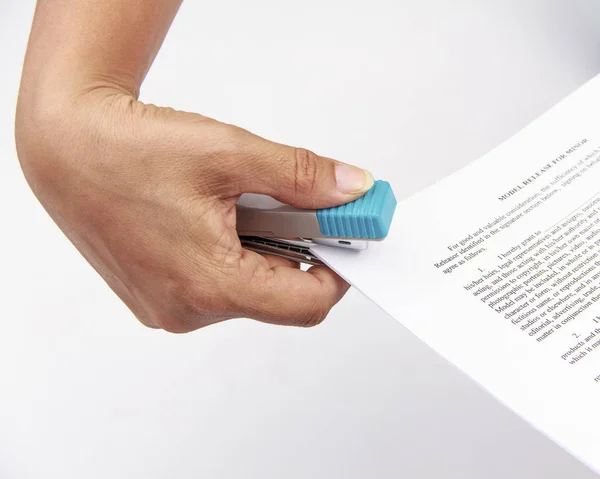 Close-up de papel de grampeamento da mão da mulher sobre fundo branco — Fotografia de Stock