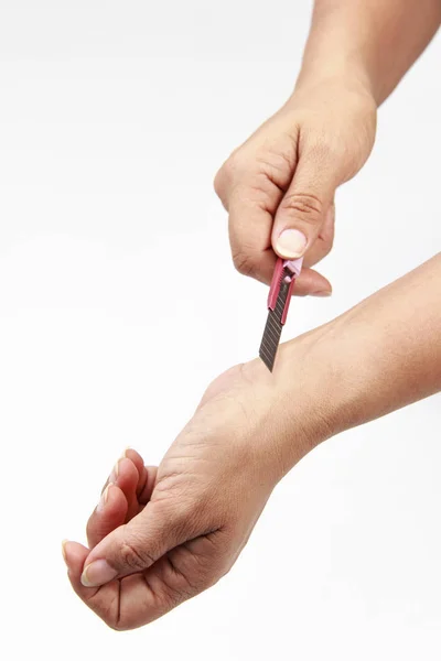 Mão da mulher cortando o pulso no fundo branco — Fotografia de Stock