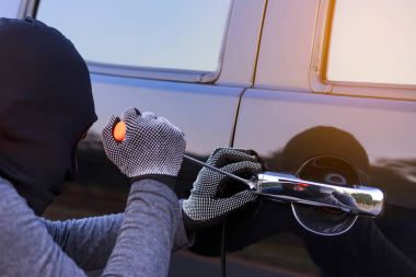 Arabanın kapısını açmaya çalışırken hırsızlar.