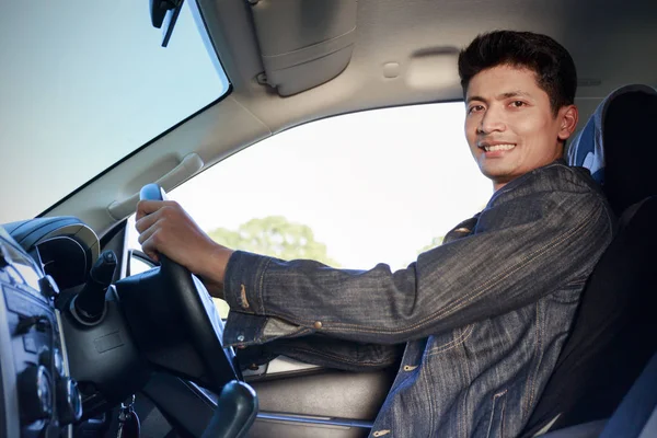 Joven sonriendo a la cámara en el coche.Concepto de estilo de vida . — Foto de Stock