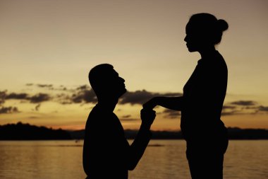 Genç adam sormak onun kız arkadaşı düğün için Sevgililer günü .silhouette kavram.