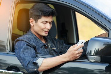  Genç kullanma smartphone arabadaki adam. Liftstyle kavramı. 