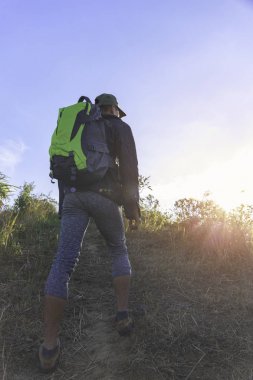 Genç bir tur güneş tepeye akşam yürüyüş sırt çantası adam. Yolculuk tutkusu kavramı.