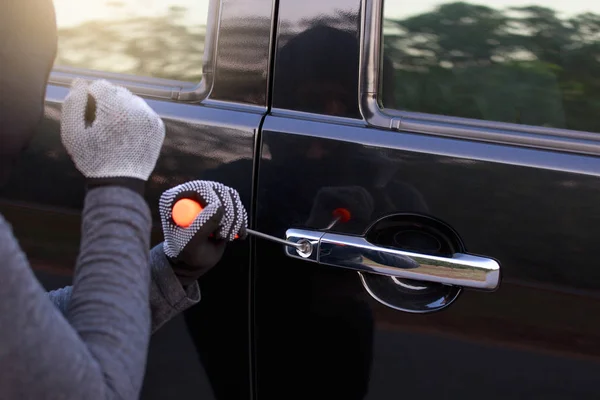 Ladrones tratando de abrir la puerta del coche . Imagen De Stock