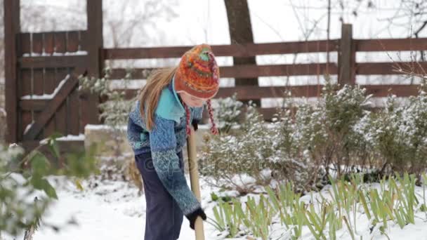 El chico quita la pala de nieve cerca de la casa. Limpieza de nieve en invierno cerca de la casa. El niño limpia la pala de la pista cubierta de nieve . — Vídeos de Stock