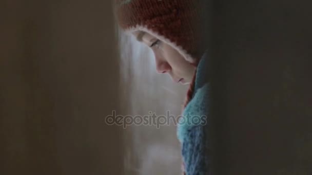 Der Junge räumt Schnee in der Nähe des Zauns. Das Kind putzt den Winter. Blick durch einen Zaun auf den Putzschnee. — Stockvideo