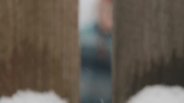 The boy looks through the doorway of the fence. Up portrait of a child peeking through the fence. Face and eyes watching the boy. — Stock Video