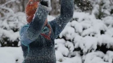 Karda parkta oynayan bir çocuk. Kışın erkek bir bebek portresi. Karda oynarken çocuk kameraya bir kartopu atar. 