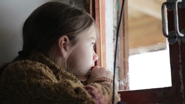 Retrato de niño en la ventana. El chico cara de cerca niño a través del vidrio. Chico triste mira por la ventana . — Vídeos de Stock