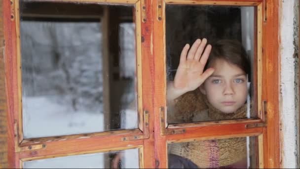 Portret van het kind in het venster. Het gezicht van de jongen is close-up van kind door middel van het glas. Trieste jongen kijkt uit het raam. — Stockvideo