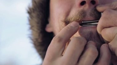 Bir harp oynayan bir adam portresi. Sakallı şaman armonika drymba çalış. Portre bir müzisyen Yahudi'nın Harp ile karşı karşıya. Yüz yakın çekim enstrüman ile Yahudi'nın Harp.