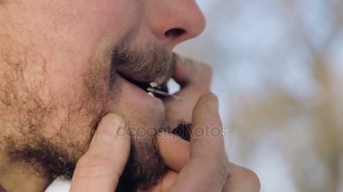 Bir harp oynayan bir adam portresi. Sakallı şaman armonika drymba çalış. Portre bir müzisyen Yahudi'nın Harp ile karşı karşıya. Yüz yakın çekim enstrüman ile Yahudi'nın Harp.