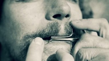 Bir harp (siyah beyaz resim) oynayan bir adam portresi. Sakallı şaman armonika drymba (siyah beyaz resim) oynuyor. Yüz enstrüman ile Yahudi'nın Harp (ses dosyasını kapat).