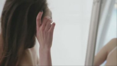 Güzel kadının dudakları aynaya boyar. Onun iç çamaşırı ayna, güzel bir genç kız portresi. 