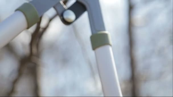 Le garçon coupe les arbres dans le jardin avec une taille. L'enfant aide à couper les arbres dans le parc au printemps. Un jardinier adolescent coupe les branches de la ferme . — Video