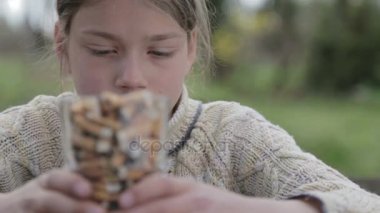 Çocuk sigara izmaritleri bir tabak içinde bakıyor. Bir genç sigara izmaritleri görünüyor. Anti tütün video. Sağlıklı bir yaşam tarzı için. 