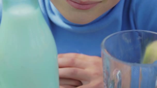 Porträt eines gesunden Kindes mit einem Glas Milch. Ein Junge trinkt in der Natur Milch. Gesunde Ernährung. die richtige Lebensweise. — Stockvideo