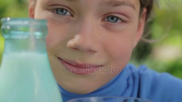 Portrét zdravé dítě se sklenicí mléka. Chlapec je konzumní mléko v přírodě. Zdravé stravování. Správný způsob života. — Stock video