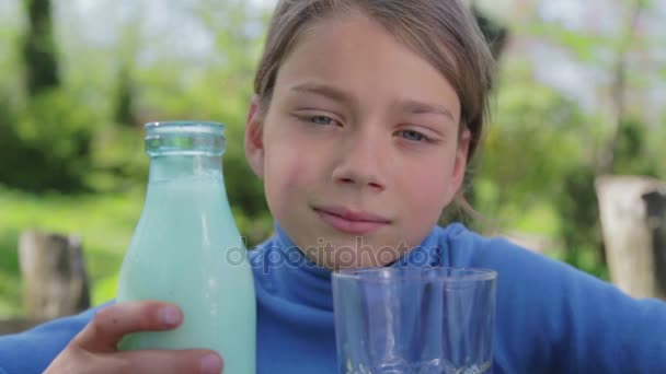 Bir bardak süt ile sağlıklı bir çocuk portresi. Bir çocuk doğada süt içiyor. Sağlıklı beslenme. Doğru şekilde yaşam. — Stok video