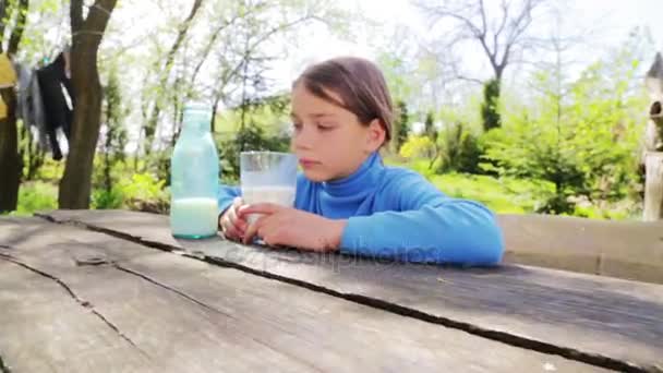 Porträtt av ett friskt barn med ett glas mjölk. En pojke konsumtionsmjölk i naturen. Sunda matvanor. På rätt sätt av liv. — Stockvideo