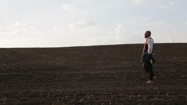 Uomo barbuto in giacca e cravatta sul campo a piedi nudi. Maschio in costume classico in natura . — Video Stock