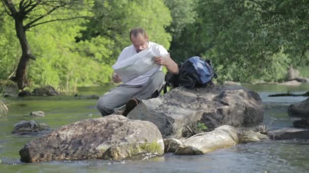Guy vousatý muž cestuje podél řeky ford. Turistický batoh přes řeku. Vousatý chlap přes řeku. — Stock video