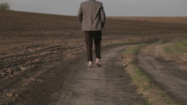 Hombre en un traje clásico en la naturaleza. Un hombre con traje se alegra y baila en el campo . — Vídeos de Stock