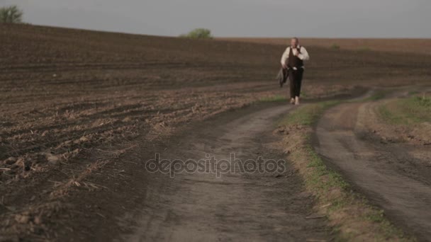 Male in a classic costume in nature. A man in a suit is glad and dances in the field. — Stock Video