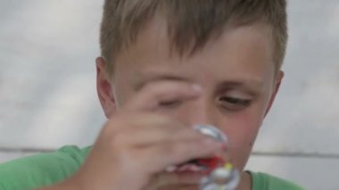 Bir değer değişimi ile oynayan bir çocuk portresi. Yüz yakın çekim bir spinner ile oynayan bir çocuk. 