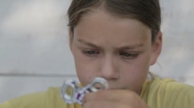 Bir değer değişimi ile oynayan bir çocuk portresi. Yüz yakın çekim bir spinner ile oynayan bir çocuk. 