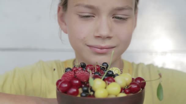 Un niño come bayas frescas de un plato. Retrato de niño de comer bayas . — Vídeos de Stock