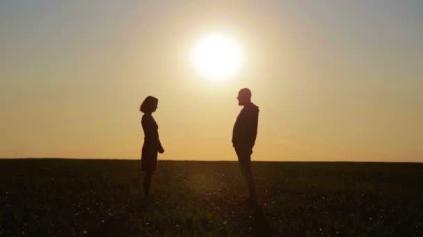 Fiatal gyönyörű pár at sunset veszekedések összehangolandó. Férfi és nő, napnyugtakor a nap területén problémák megoldása. — Stock videók