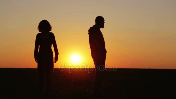 Fiatal gyönyörű pár at sunset veszekedések összehangolandó. Férfi és nő, napnyugtakor a nap területén problémák megoldása. — Stock videók