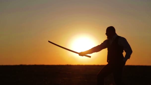 Portret van een man met een zwaard bij zonsondergang, het pad van een strijder. Samurai yakuza met een zwaard bij zonsondergang van de dag. Sport, hobby's, interesses. — Stockvideo