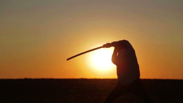 Portret van een man met een zwaard bij zonsondergang, het pad van een strijder. Samurai yakuza met een zwaard bij zonsondergang van de dag. Sport, hobby's, interesses. — Stockvideo