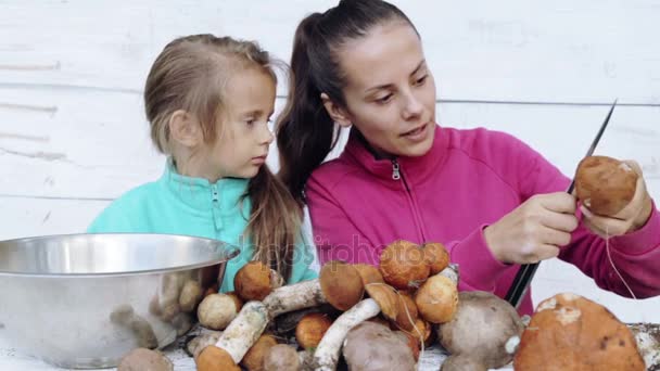 Mutter und Tochter säubern frisch gepflückte Pilze. Porträt einer Mutter mit ihrem Kind bei der Reinigung ökologisch sauberer Lebensmittel. Essen, Kochen, Umweltfreundlichkeit. — Stockvideo